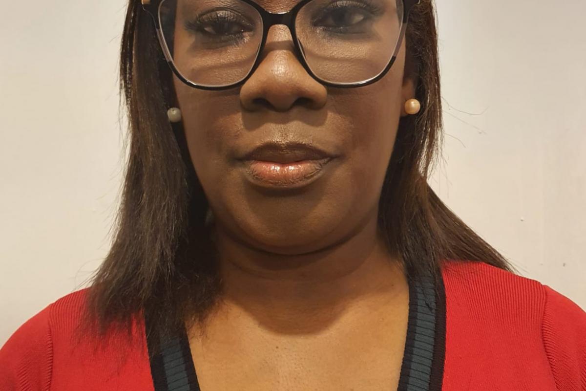 Olufunmilayo with glasses and in red V-neck jumper