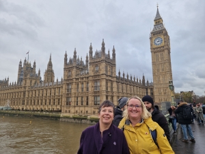 Two female OTs standing in front of the Houses of Parliament