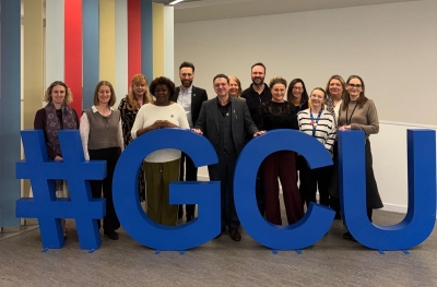 Gary and Odeth standing for a photo with teaching staff from the GCU OT team