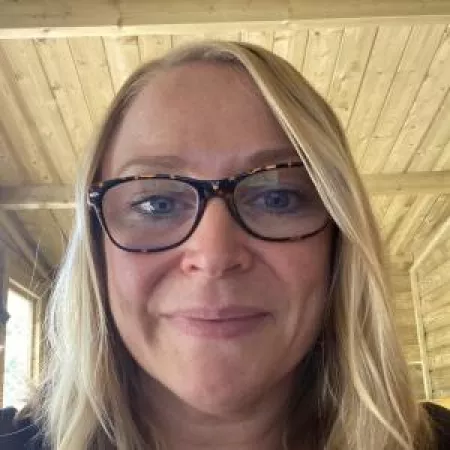 Headshot of women with blonde hair and glasses