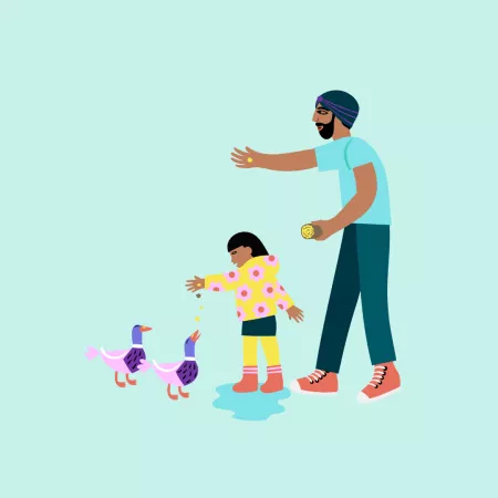 Dad feeding ducks with child