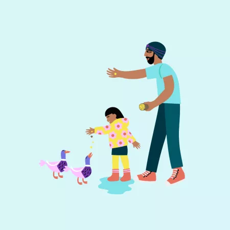 Dad feeding ducks with child