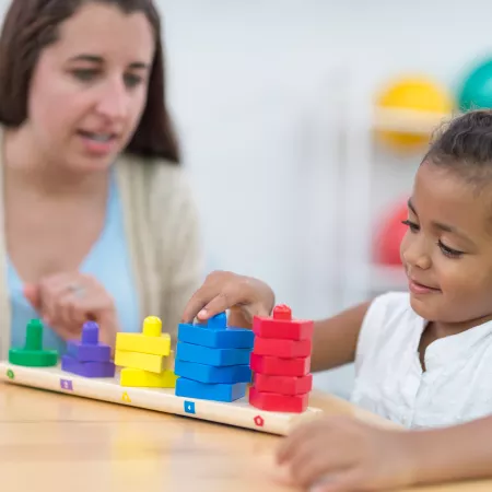 Mother and daughter playing with coloured blocks