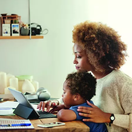 Women sits with young boy on a laptop