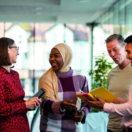 Group of people smiling and having a conversation in a business environment