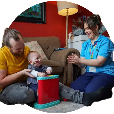 Family and occupational therapists play with baby