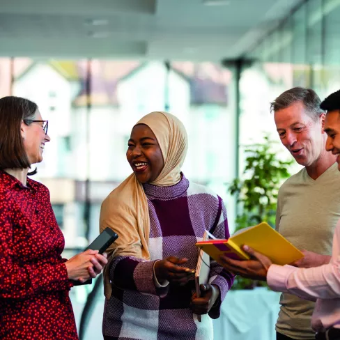 Group of people smiling and having a conversation in a business environment