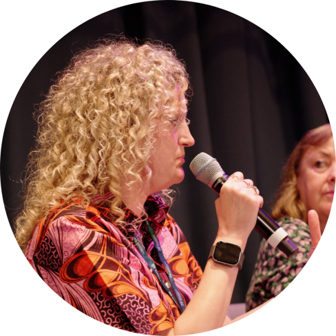 Lauren Walker speaking at event, holding microphone